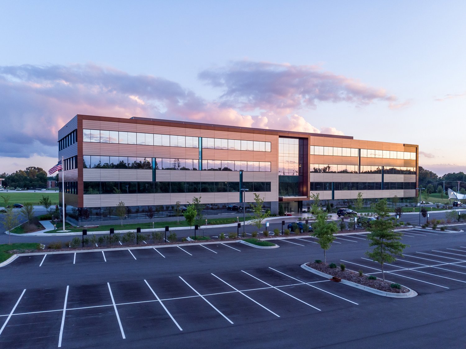 Office Building Exterior with Parking Lot Evening shot of office building exterior with large parking lot